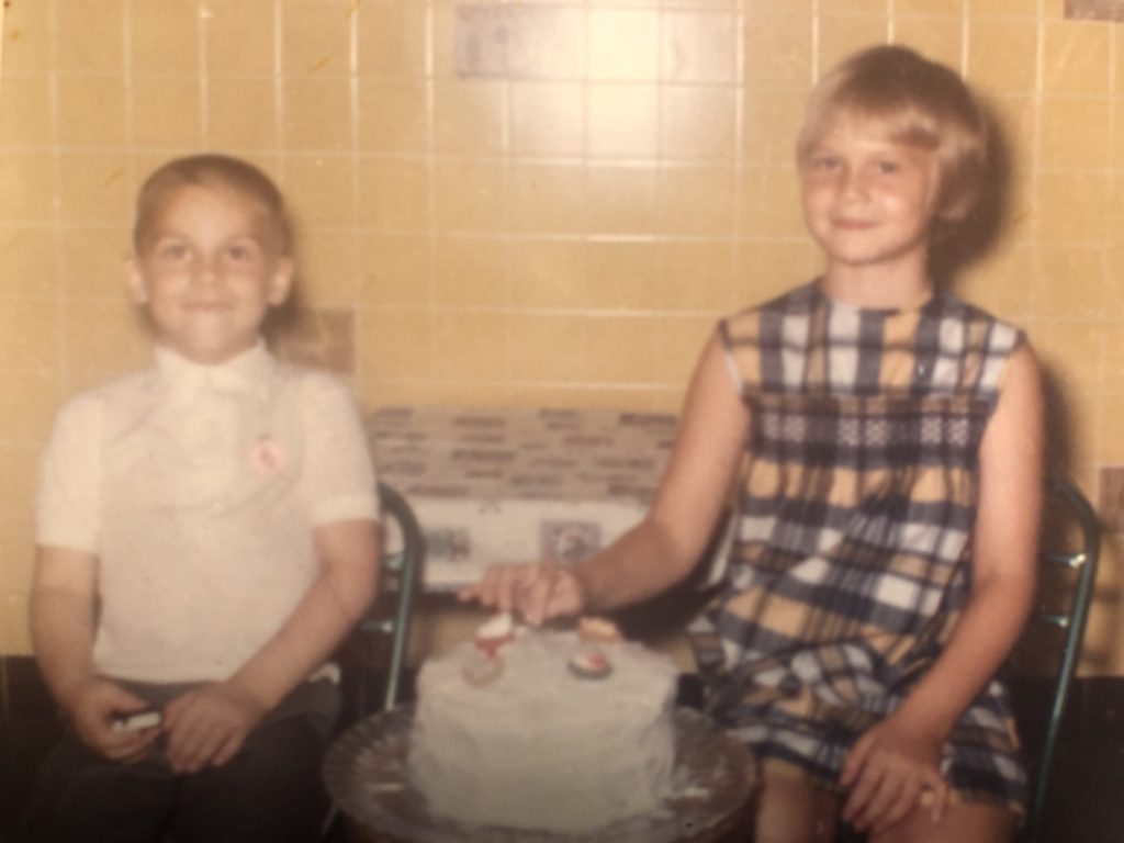 2 kids beside a cake