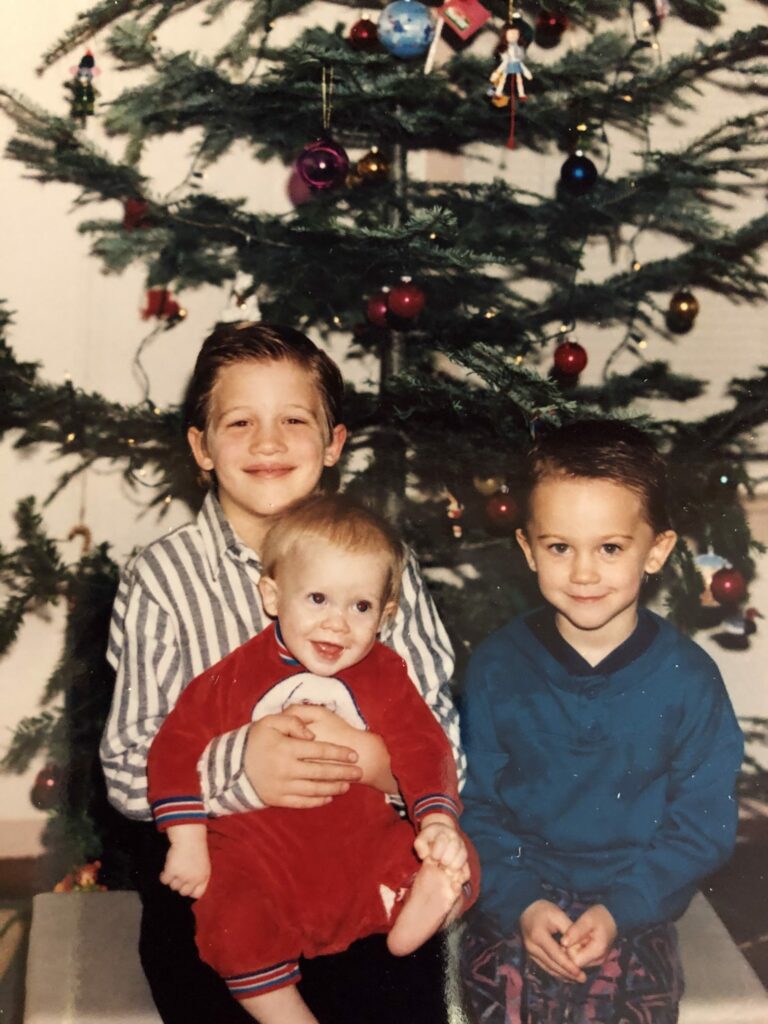 3 kids below a Christmas tree