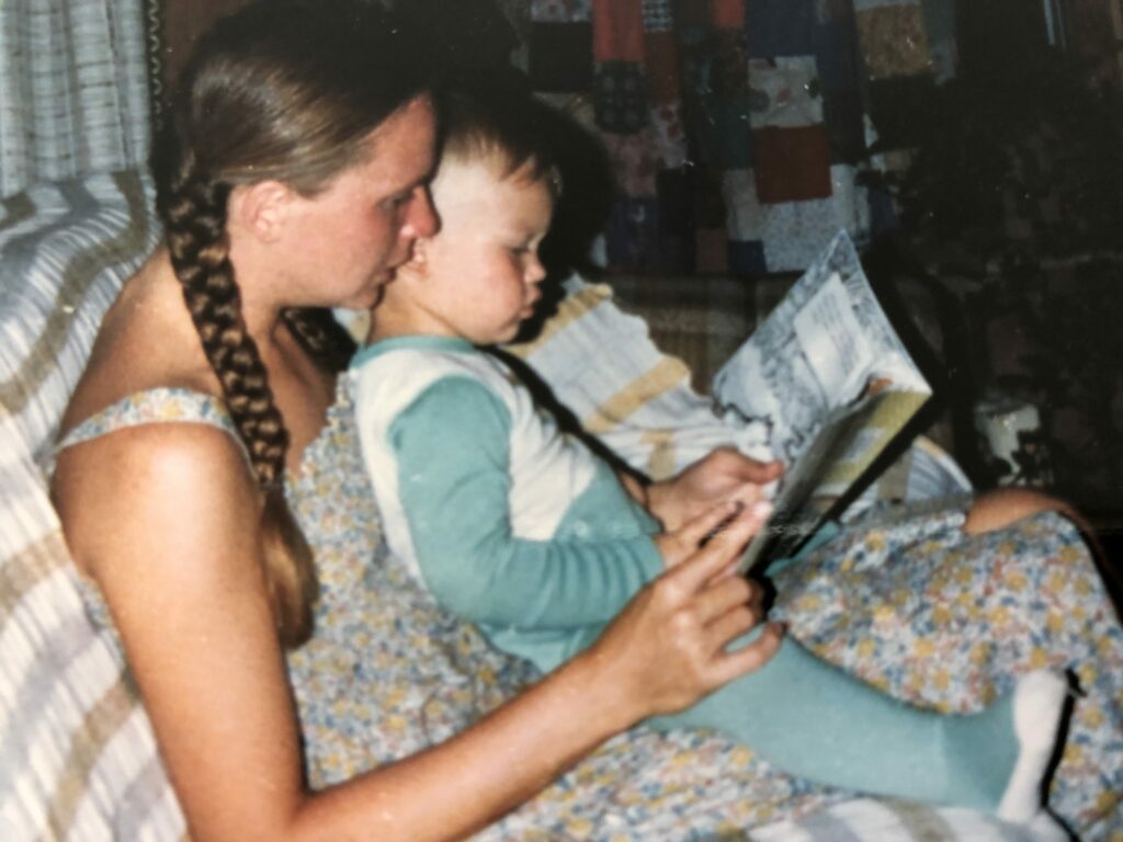 woman and a kid on her lap with a book